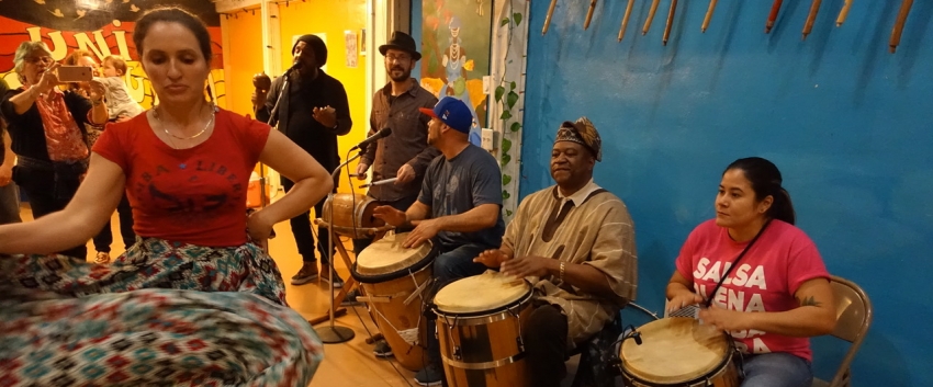 Amarilys Rios (seated, with drum), participates in a community bombazo. 