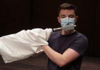 Wind Ensemble member Drew Burky (flute) adjusted to extra layers of protection for Autumn Quarter in-person rehearsals at Meany Hall (Photo: Gary Louie).  Wind Ensemble members adjusted to extra layers of protection for Autumn Quarter in-person rehearsals at Meany Hall (Photo: Gary Louie).